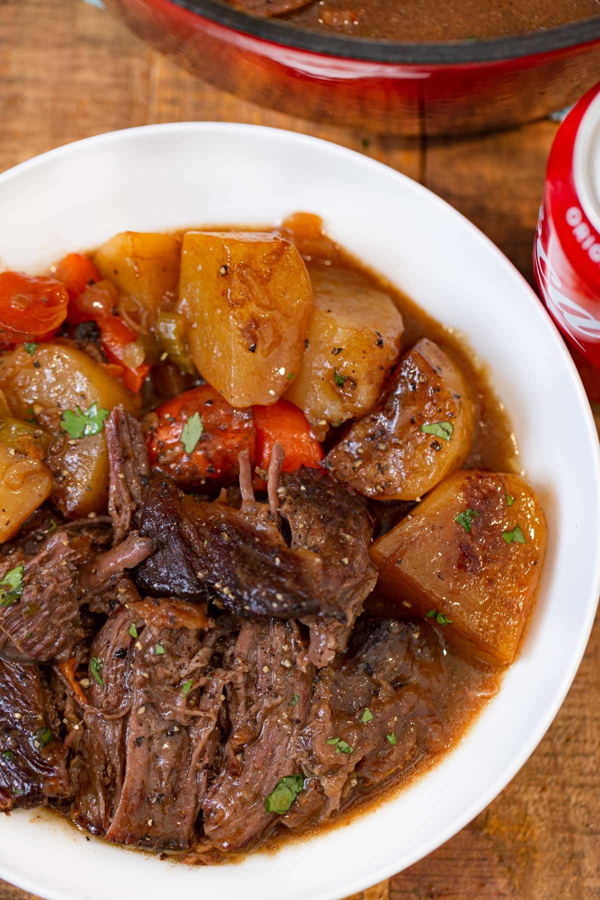 Coca Cola Pot Roast serving on plate with potatoes and carrots