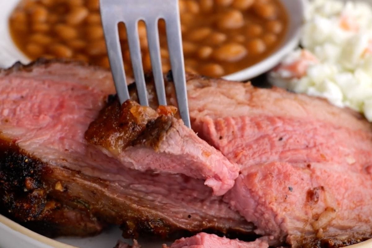 Easy Tri-Tip on plate with coleslaw and beans being cut