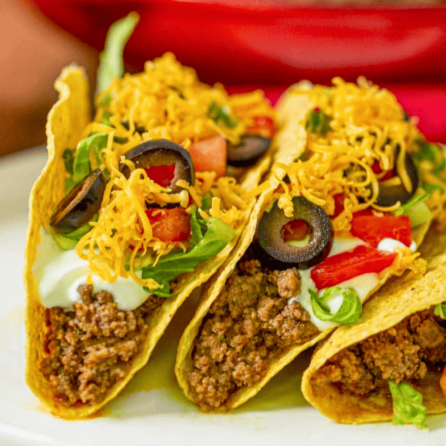 Assembled beef tacos with toppings on plate