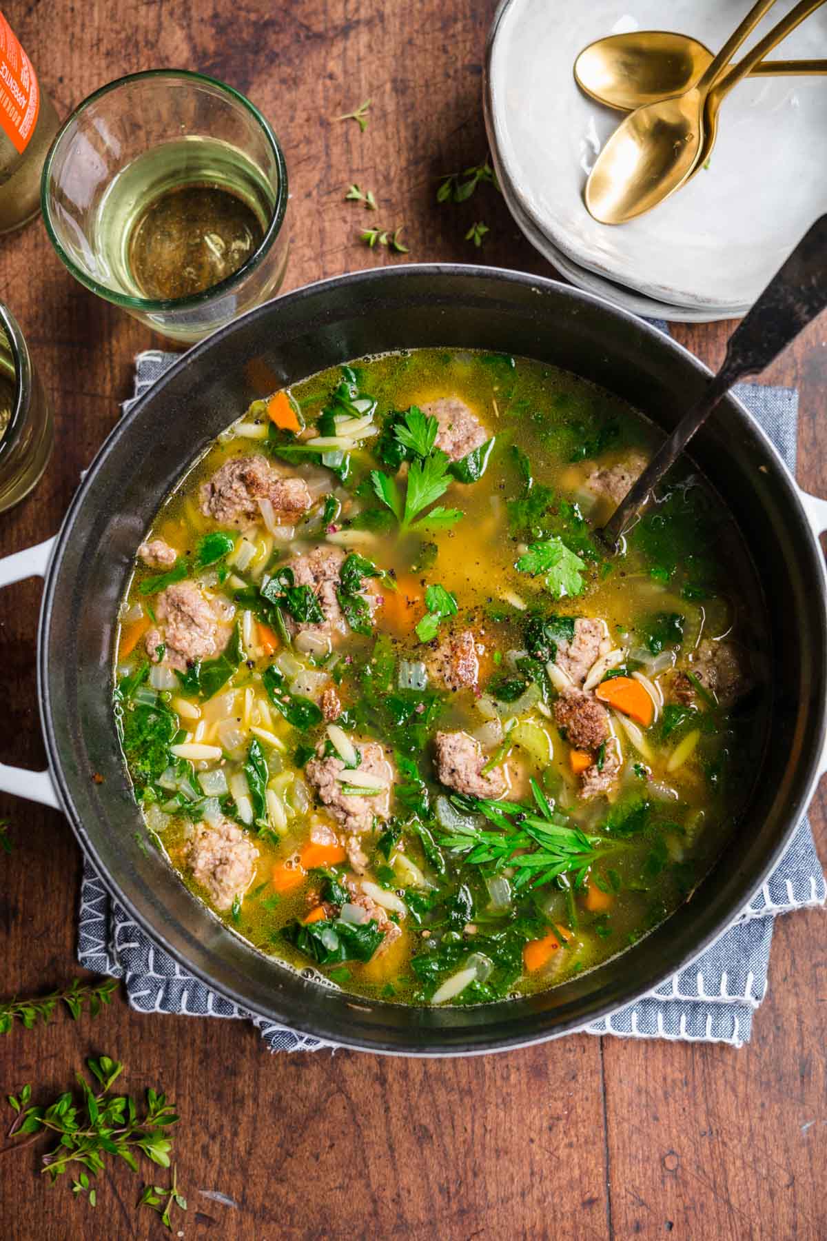Italian Wedding Soup in pot with spoon and parsley garnish