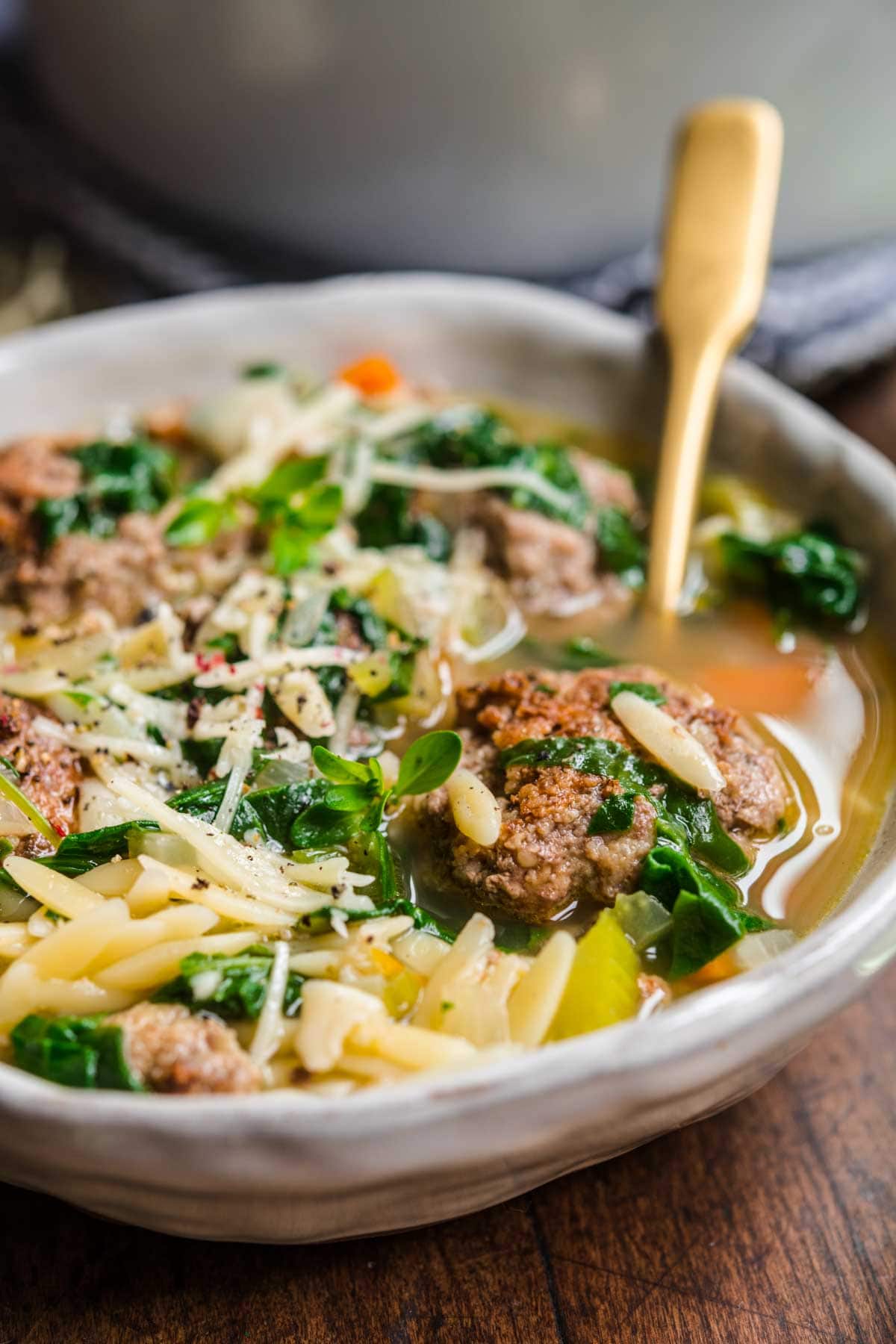 Italian Wedding Soup in bowl with spoon and parsley garnish