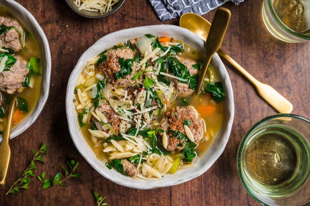 Italian Wedding Soup in bowl with spoon and parsley garnish
