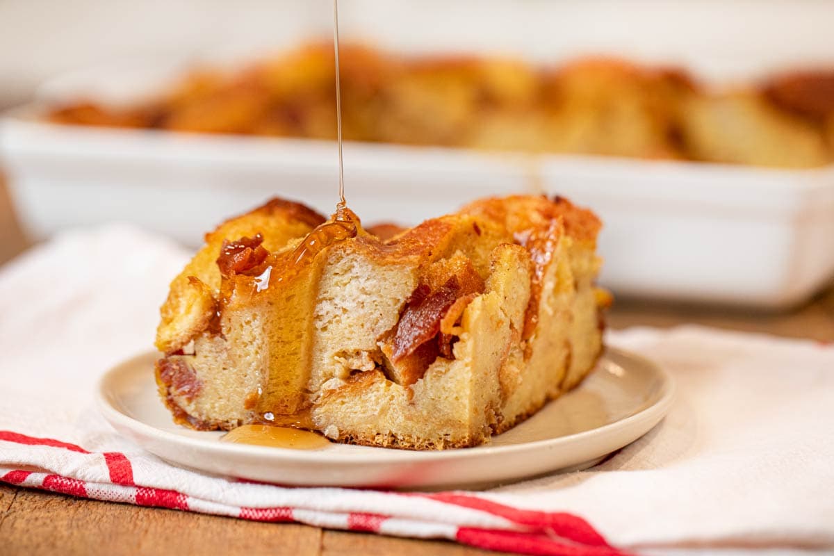 Maple Bacon French Toast Bake serving on plate with poured syrup