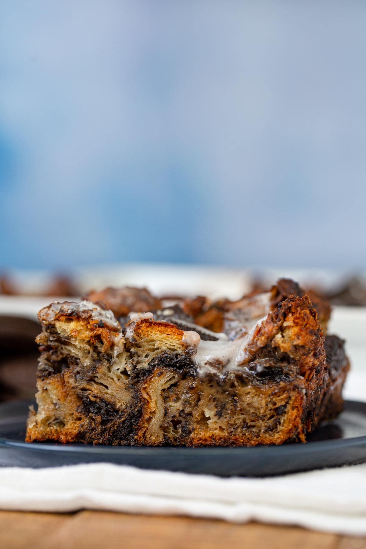 Oreo Croissant Bread Pudding on plate with blue background