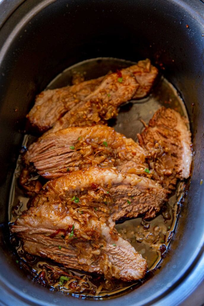 Slow Cooker Beer and Onion Brisket slices in crock pot