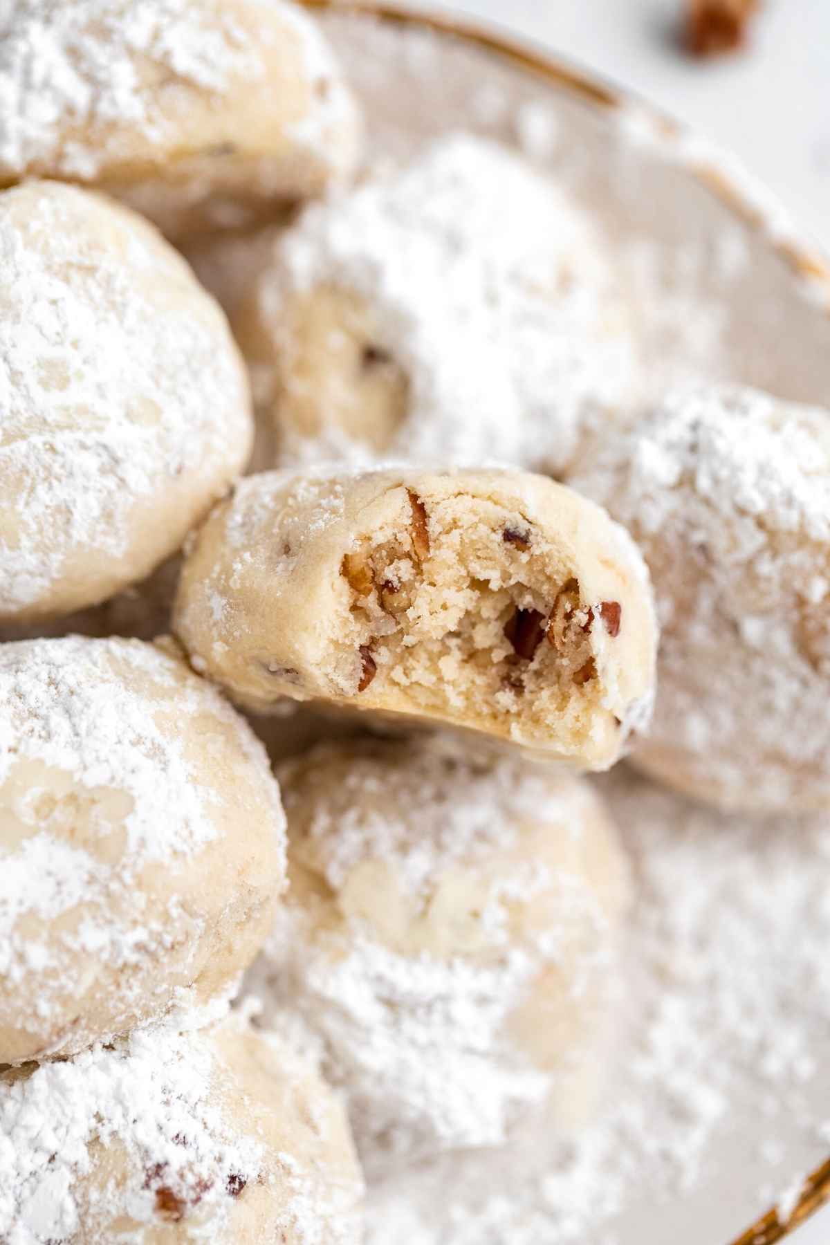 Snowball Cookies on serving plate with bite taken