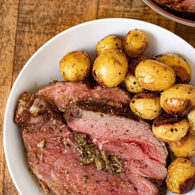 Stuffed Leg of Lamb on plate with potatoes