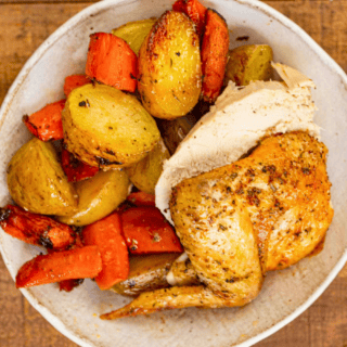 cooked sliced poultry with potatoes and carrots on a plate