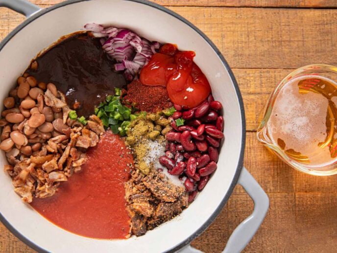 Chili ingredients in pot and beer in measuring cup