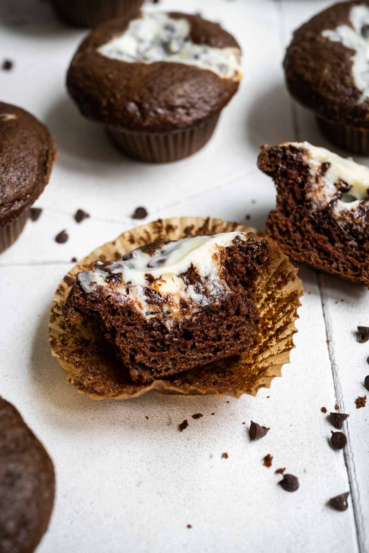 Black Bottom Cupcakes on counter with chocolate chips cut in half to see filling