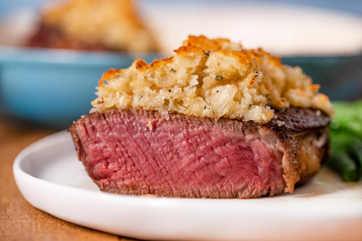 Blue Cheese Crusted Filet Mignon sliced open on plate with green beans