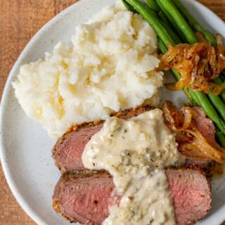 Blue Cheese Sauce over steak on plate
