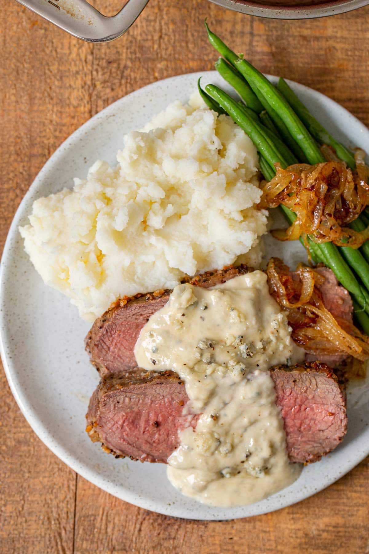 Blue Cheese Sauce over steak on plate