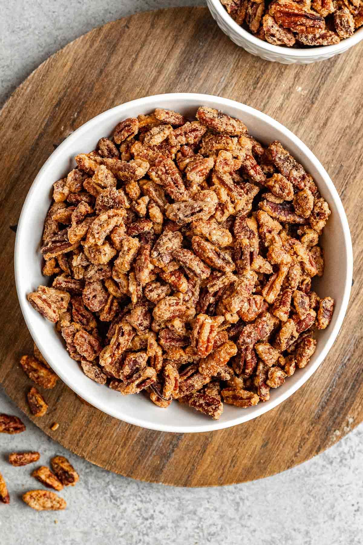 Candied Pecans in serving bowl on wood round