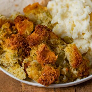 Cooked dressing on plate with turkey and mashed potatoes