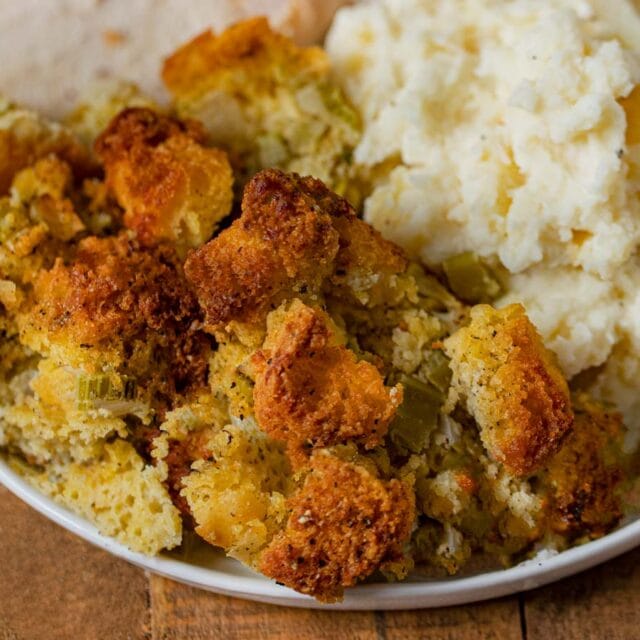 Cooked dressing on plate with turkey and mashed potatoes