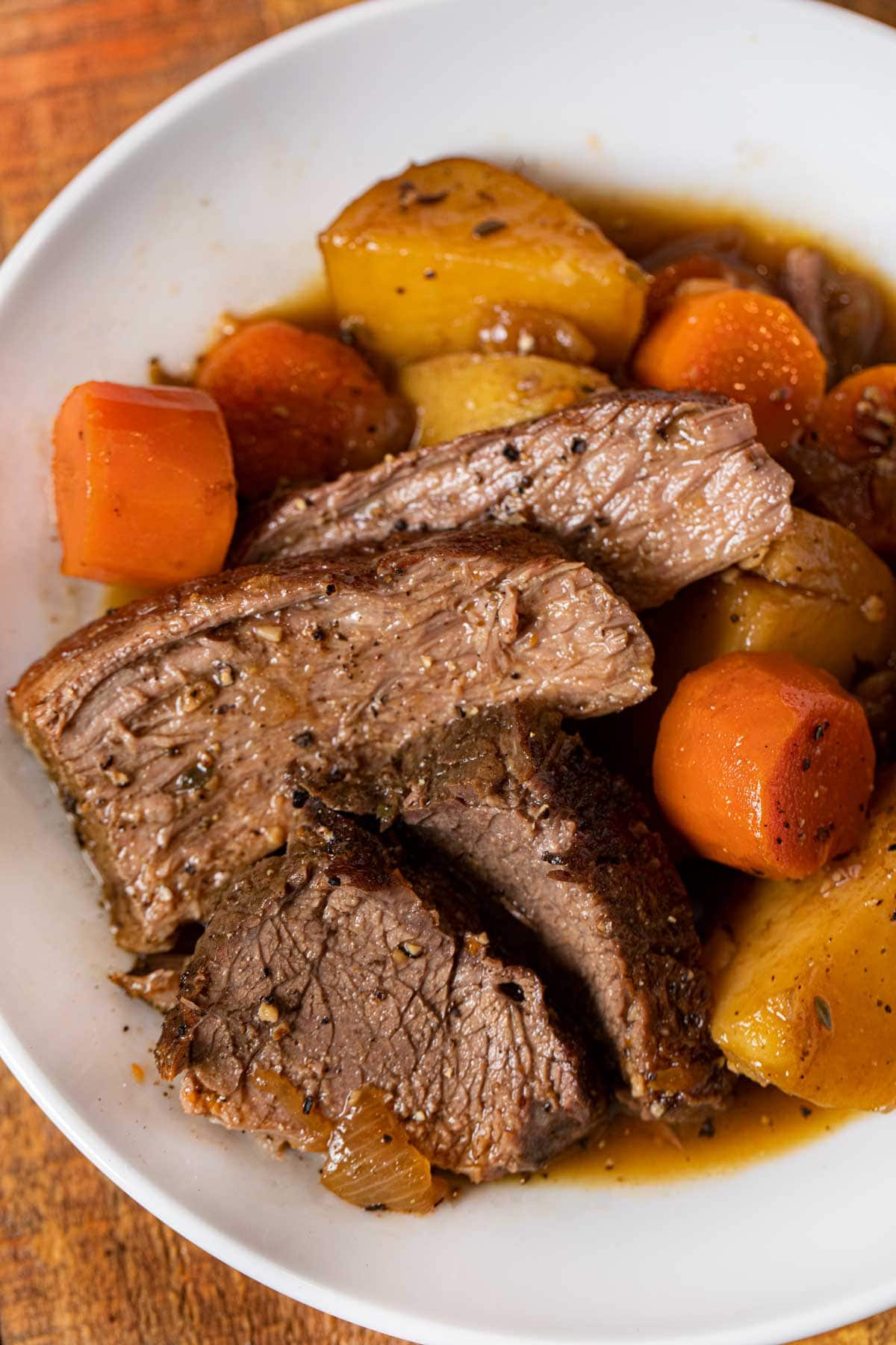 Easy Rump Roast serving on plate with potatoes and carrots