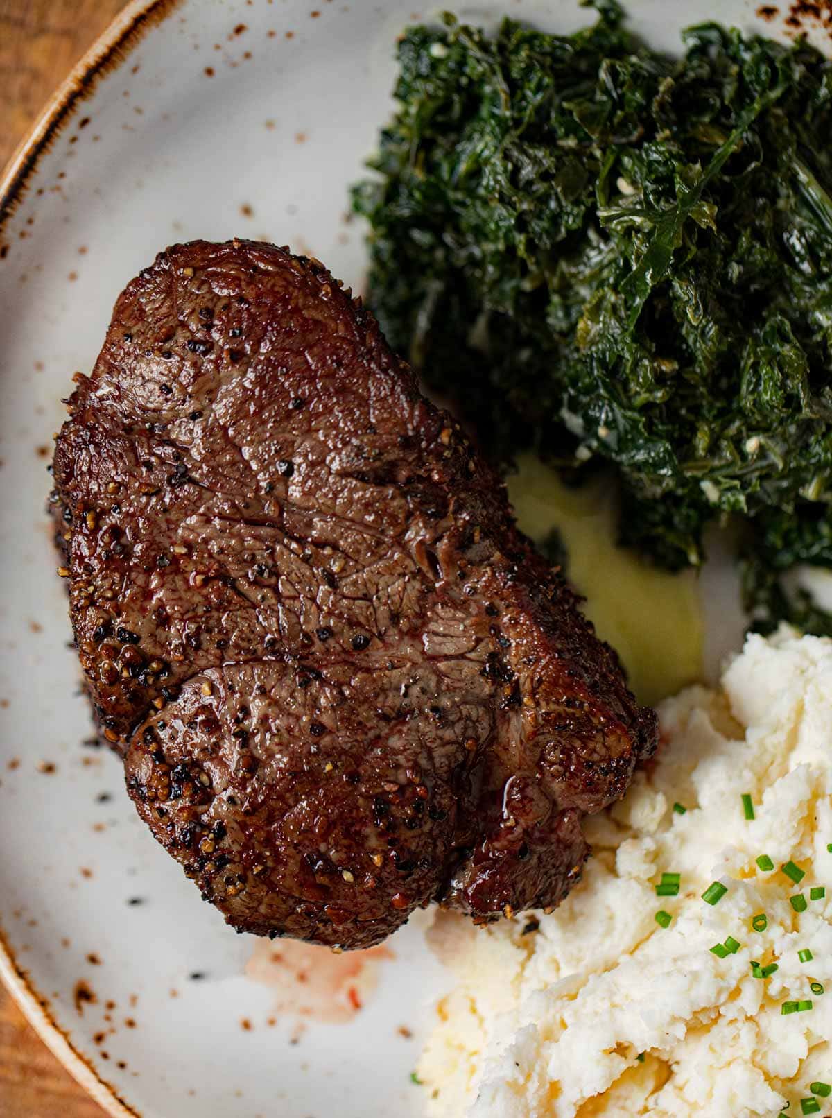 Filet Mignon on plate with mashed potatoes and spinach