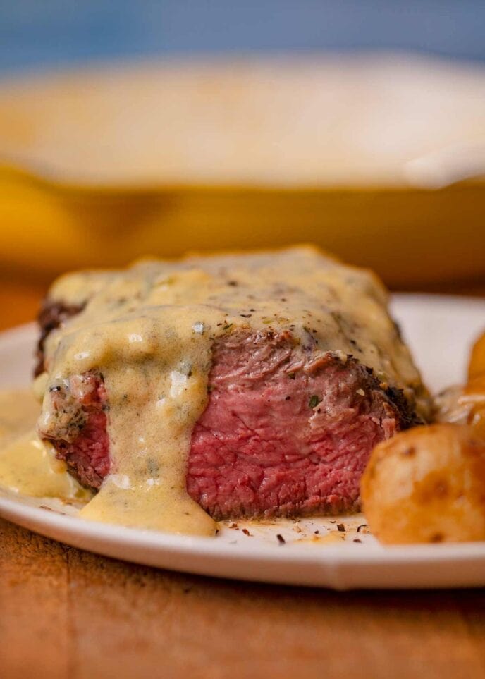 Filet with Bernaise Sauce, sliced open on plate with roasted potatoes