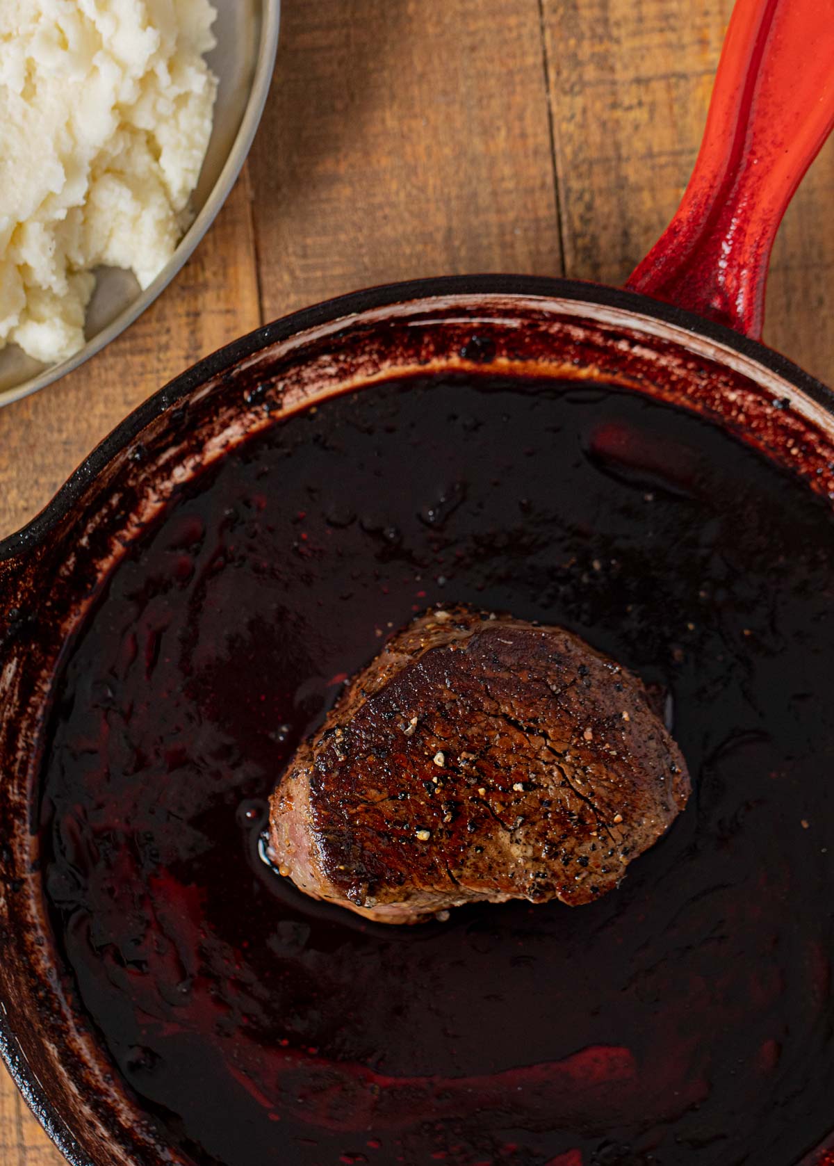 Filet with Red Wine Reduction sauce in skillet with steak