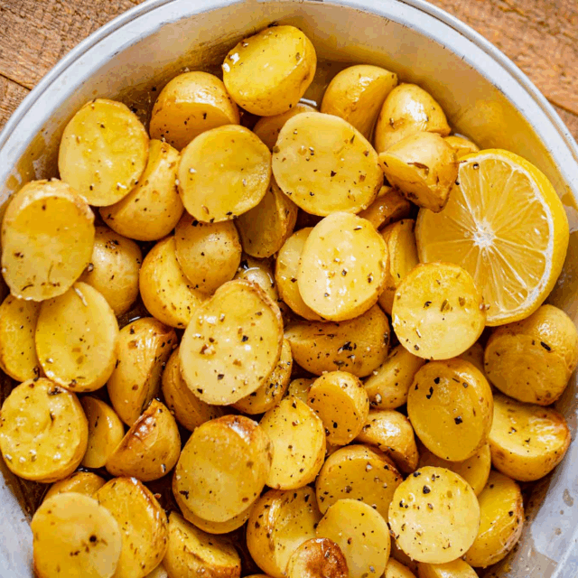 White bowl of potatoes with lemon slicces