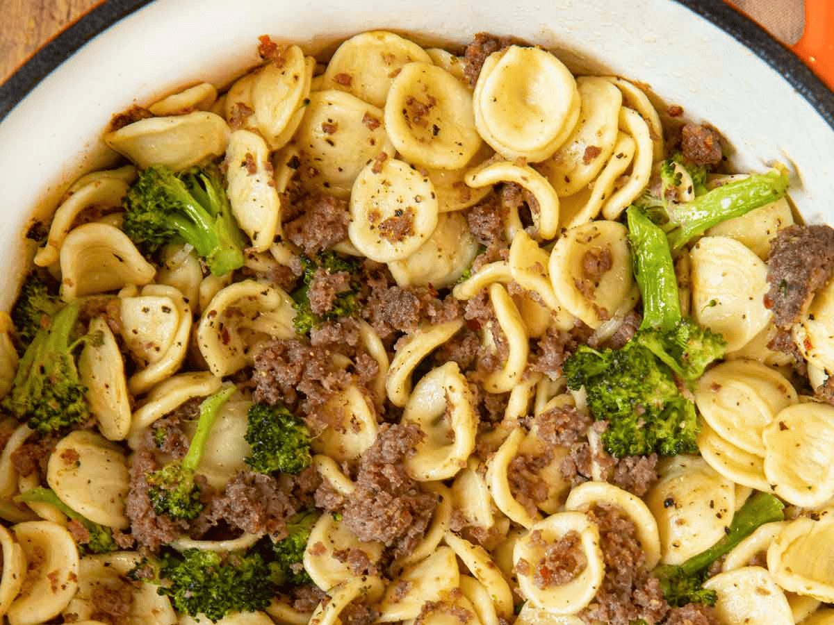 close up of pasta, meat, and green veggies in pot