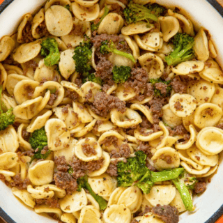 aerial view of a full pot of pasta, meat, and green veggies