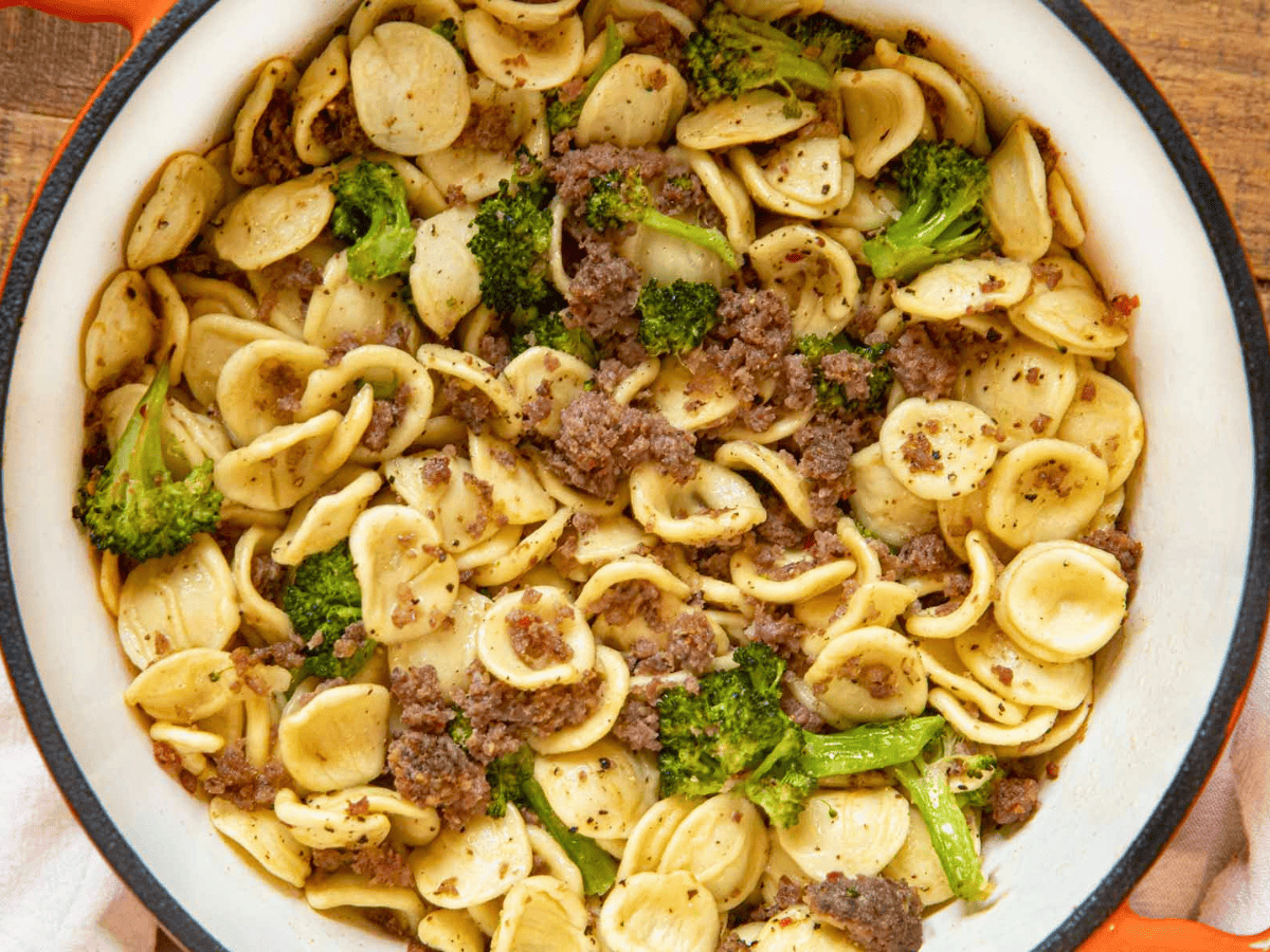 aerial view of a full pot of pasta, meat, and green veggies