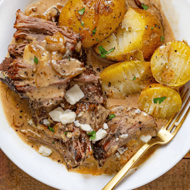 Meat and potatoes in broth with a fork