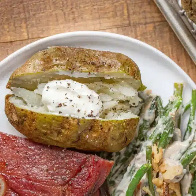 Potato with sour cream on white plate