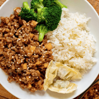 ground poultry on a plate of rice, dumplings, and broccoli