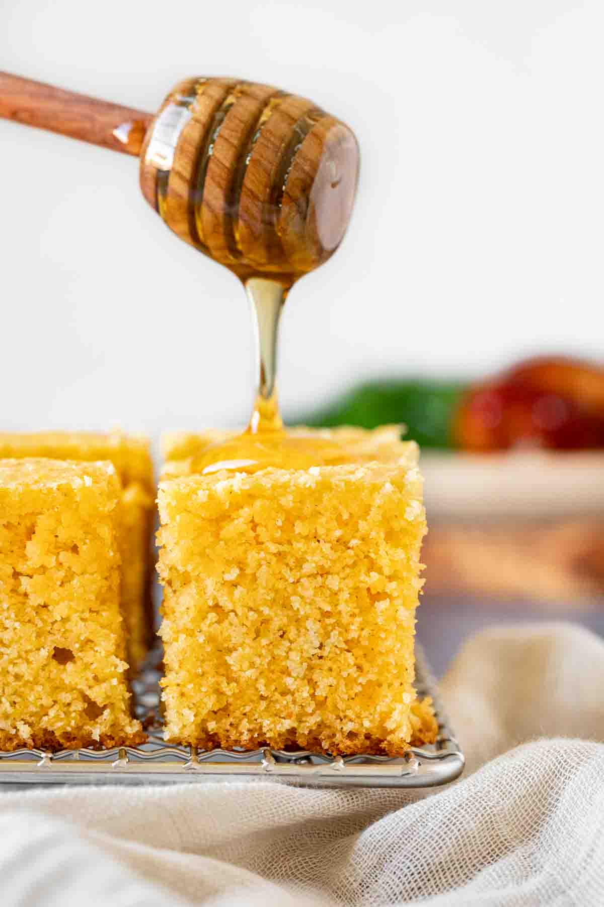 Honey Cornbread slice on wire rack with honey drizzled