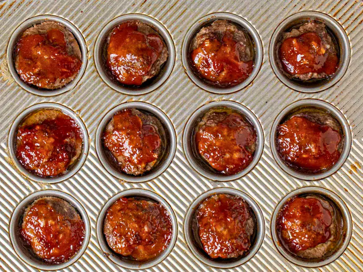 cooked ground beef in a circular baking tin pan topped with sauce
