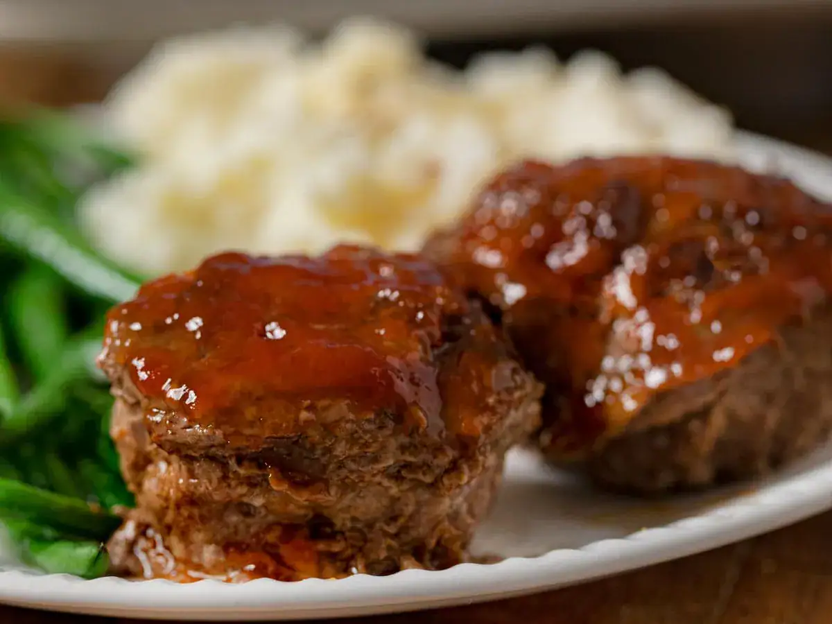 Two mini meatloaves with sauce on a plate