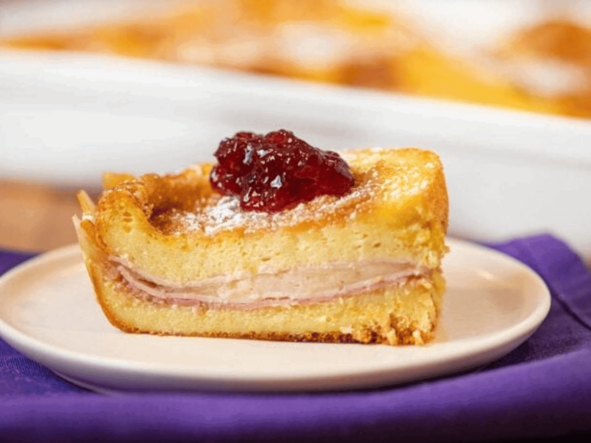 slice of casserole on a white plate topped with jam