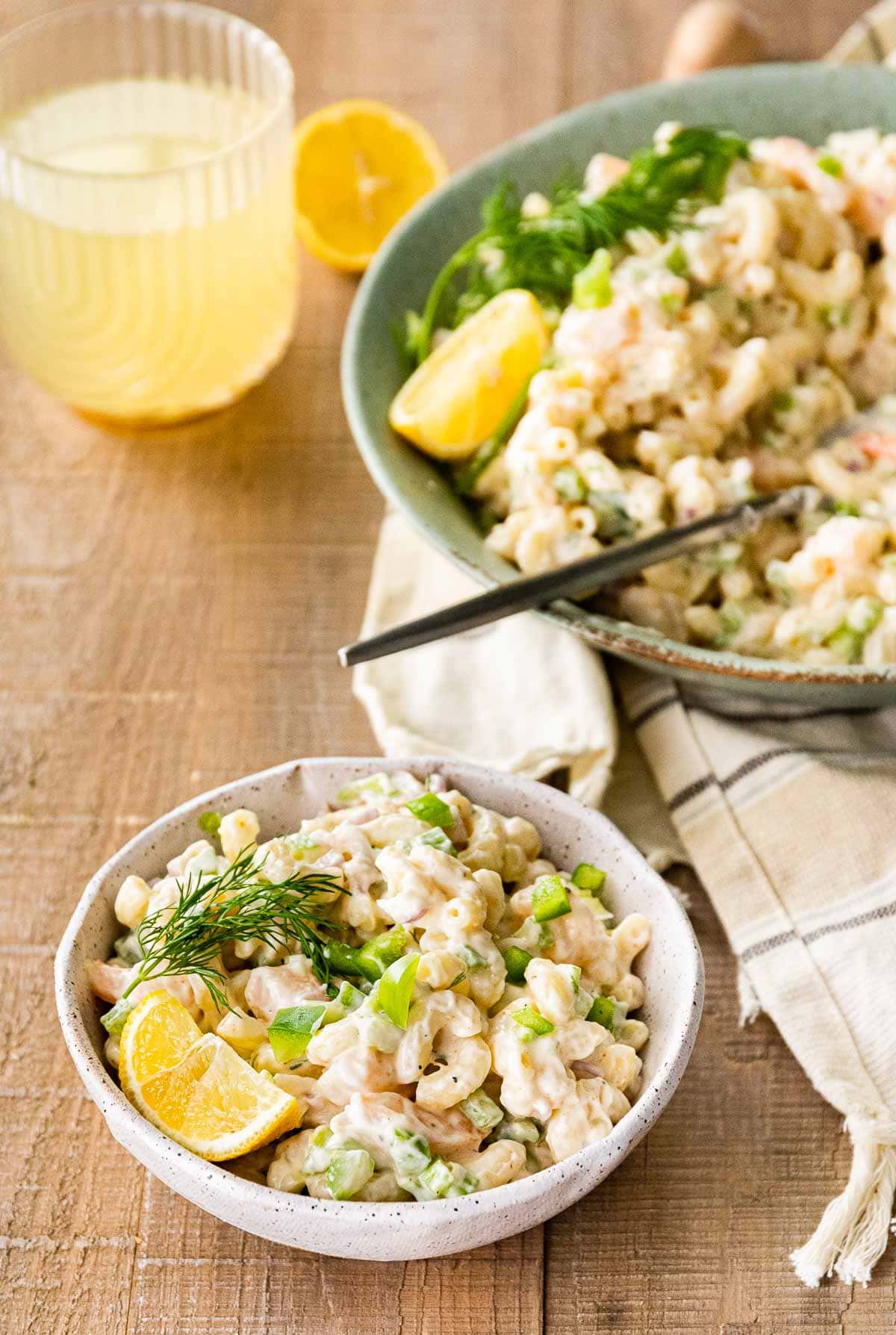 Creamy Shrimp Pasta Salad in serving bowl with fresh dill and lemon wedge garnish