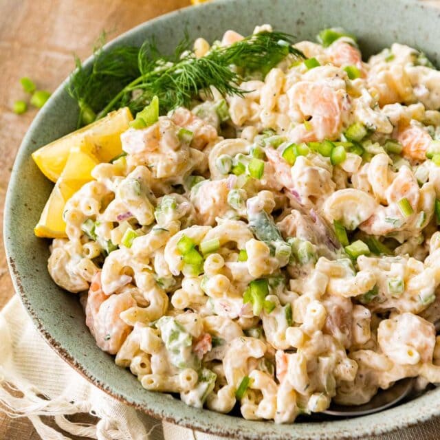 Creamy Shrimp Pasta Salad in serving bowl with fresh dill and lemon wedge garnish