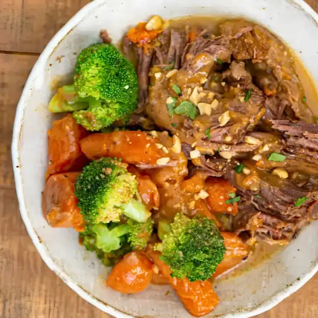 chunks of beef with carrots and broccoli in a white bowl