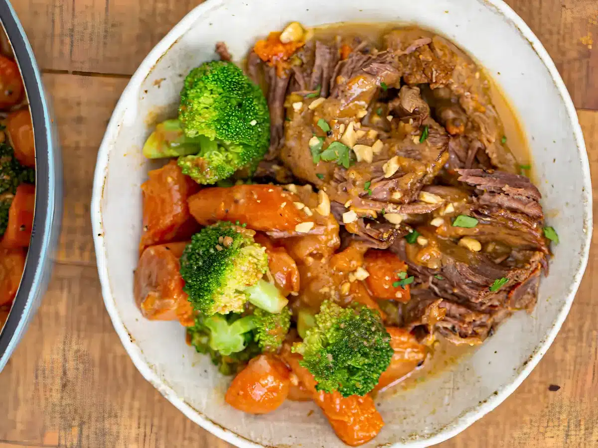 chunks of beef with carrots and broccoli in a white bowl