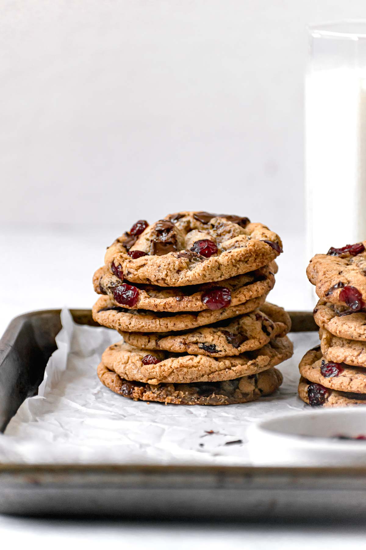 Cranberry Chocolate Chunk Cookies stacked on parchment