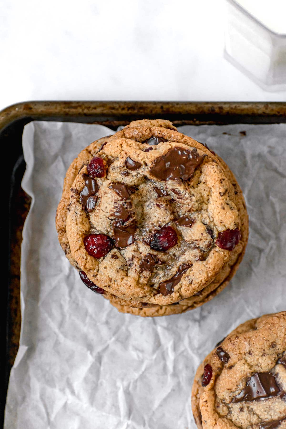 Cranberry Chocolate Chunk Cookies stacked on parchment