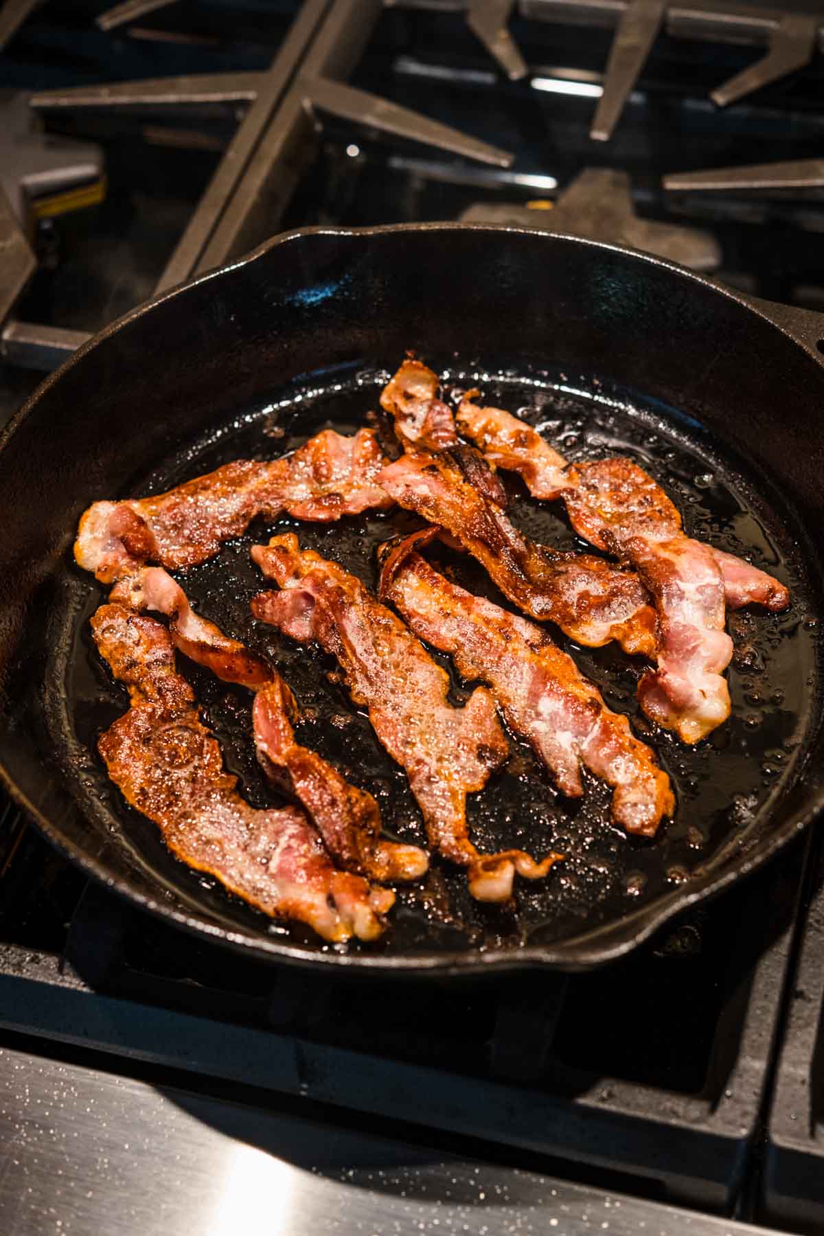 Bacon frying in cast iron pan for Bacon Cheeseburger Tater Tot Casserole