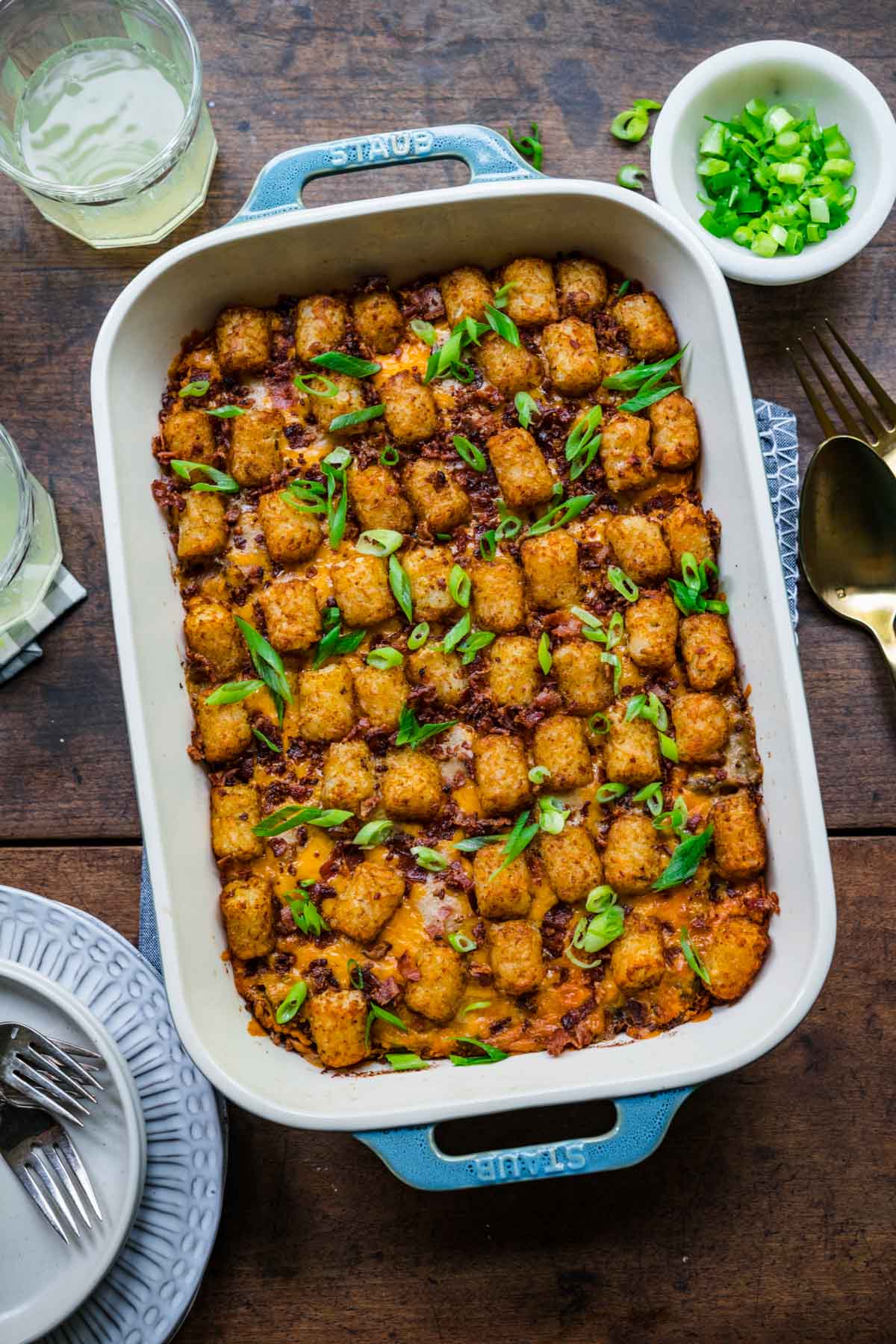 Finished Bacon Cheeseburger Tater Tot Casserole in 9x13 pan with bacon and green onions garnish