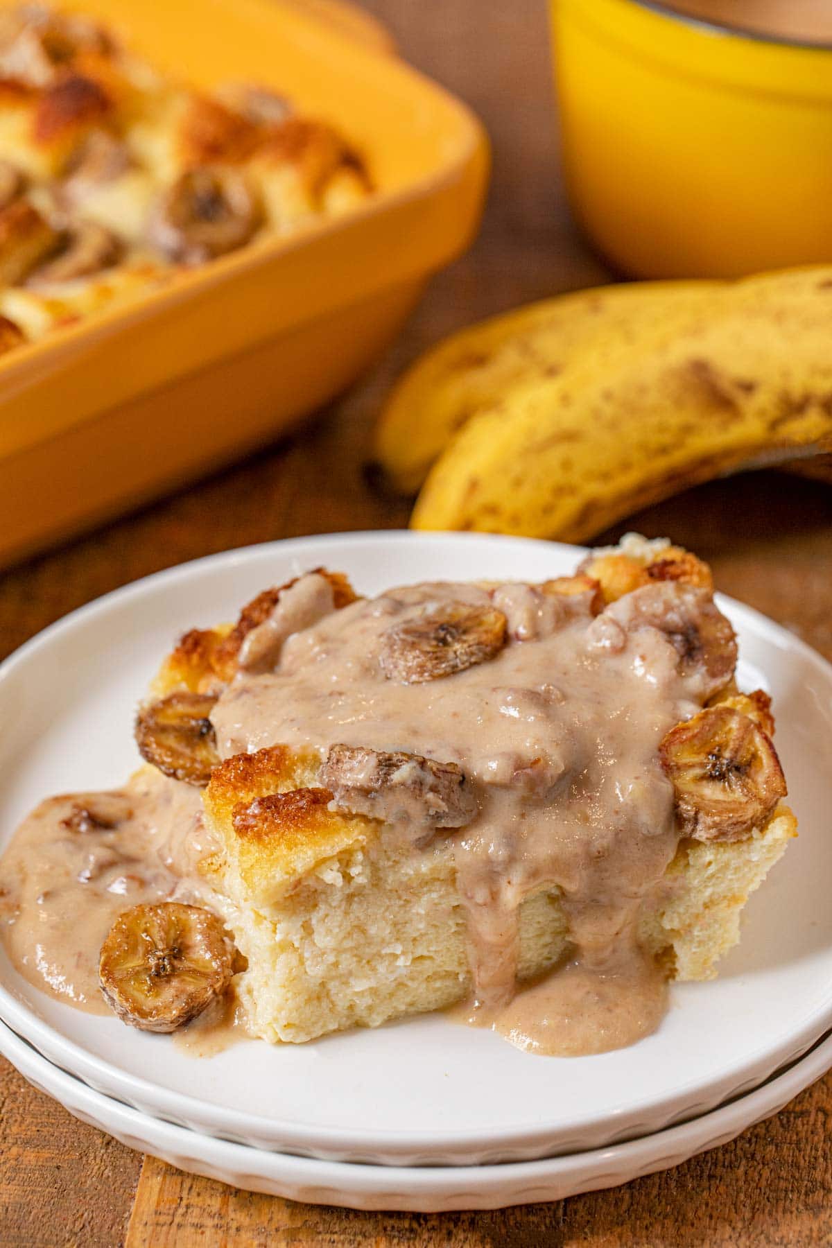 Banana Bread Pudding serving on plate with pecan vanilla sauce