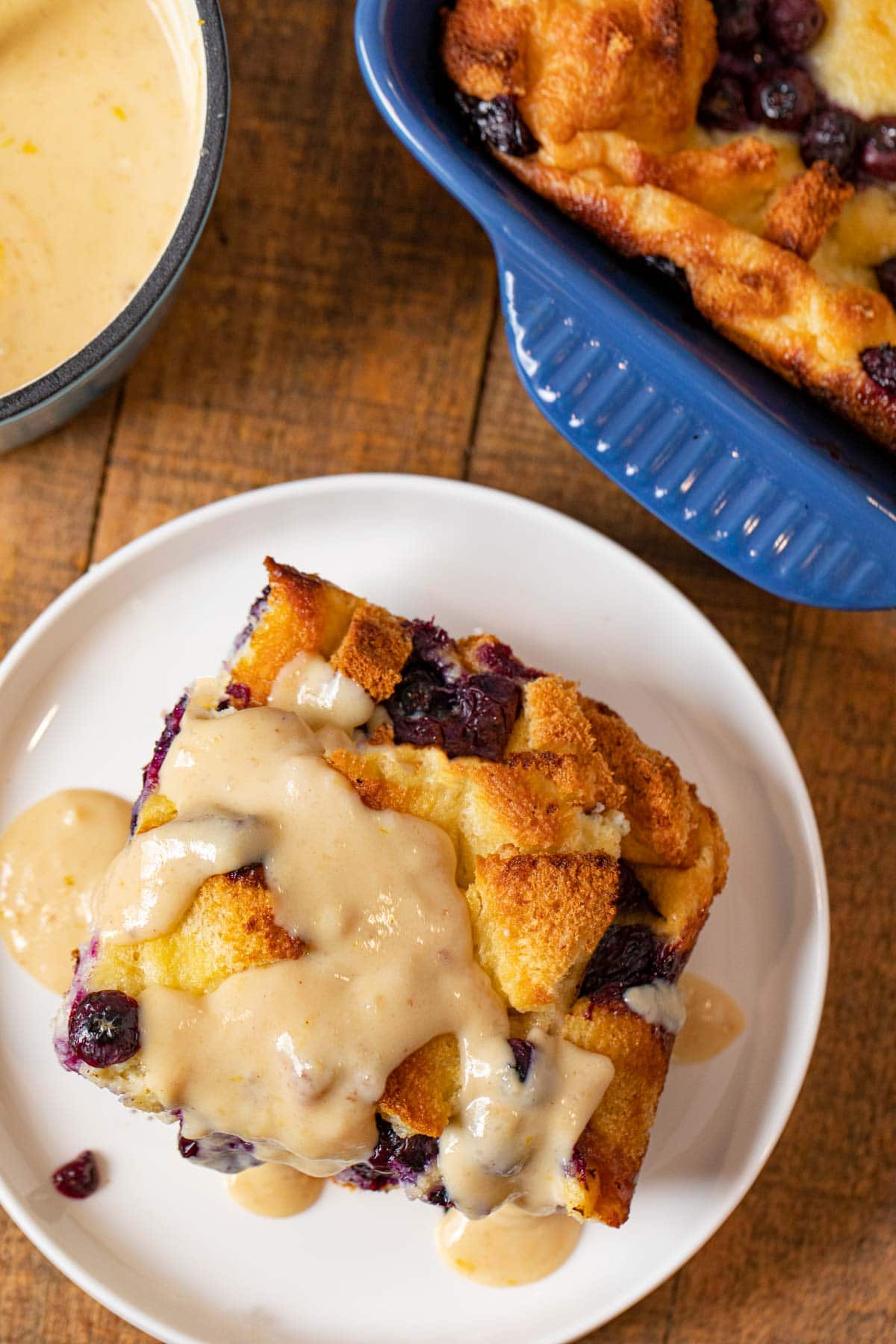 top-down view of Blueberry Bread Pudding serving on plate with lemon-vanilla glaze