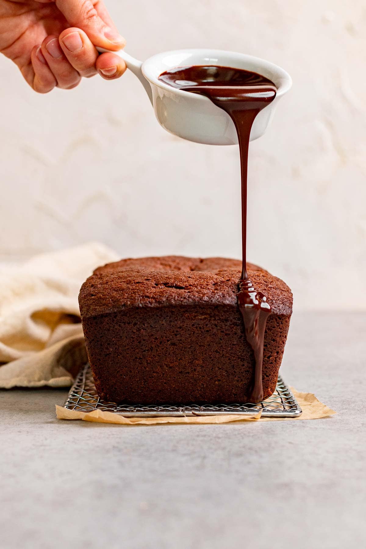 Chocolate Pound Cake on wire rack being glazed with ganace