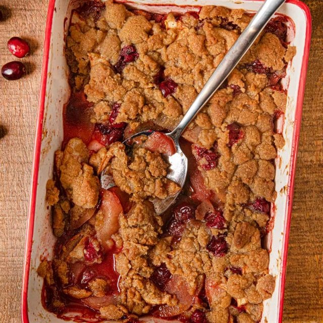 Apple Cranberry Crisp in baking dish with spoon