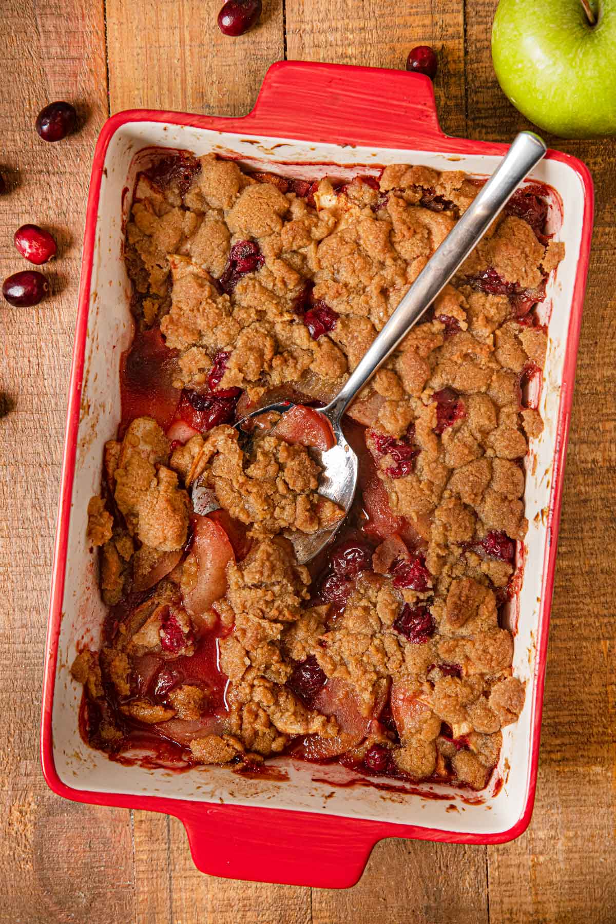 Apple Cranberry Crisp in baking dish with spoon