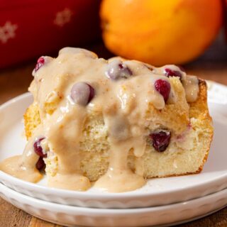 Cranberry Bread Pudding serving on plate with orange vanilla sauce