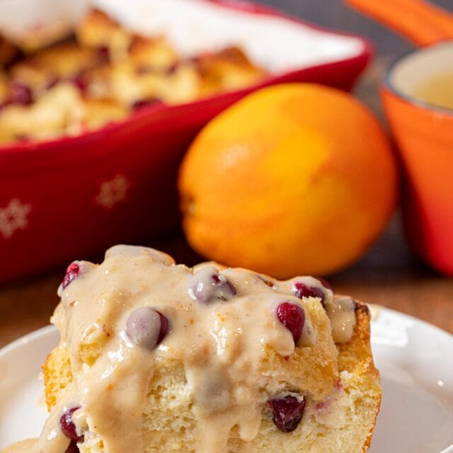 Cranberry Bread Pudding serving on plate with orange vanilla sauce